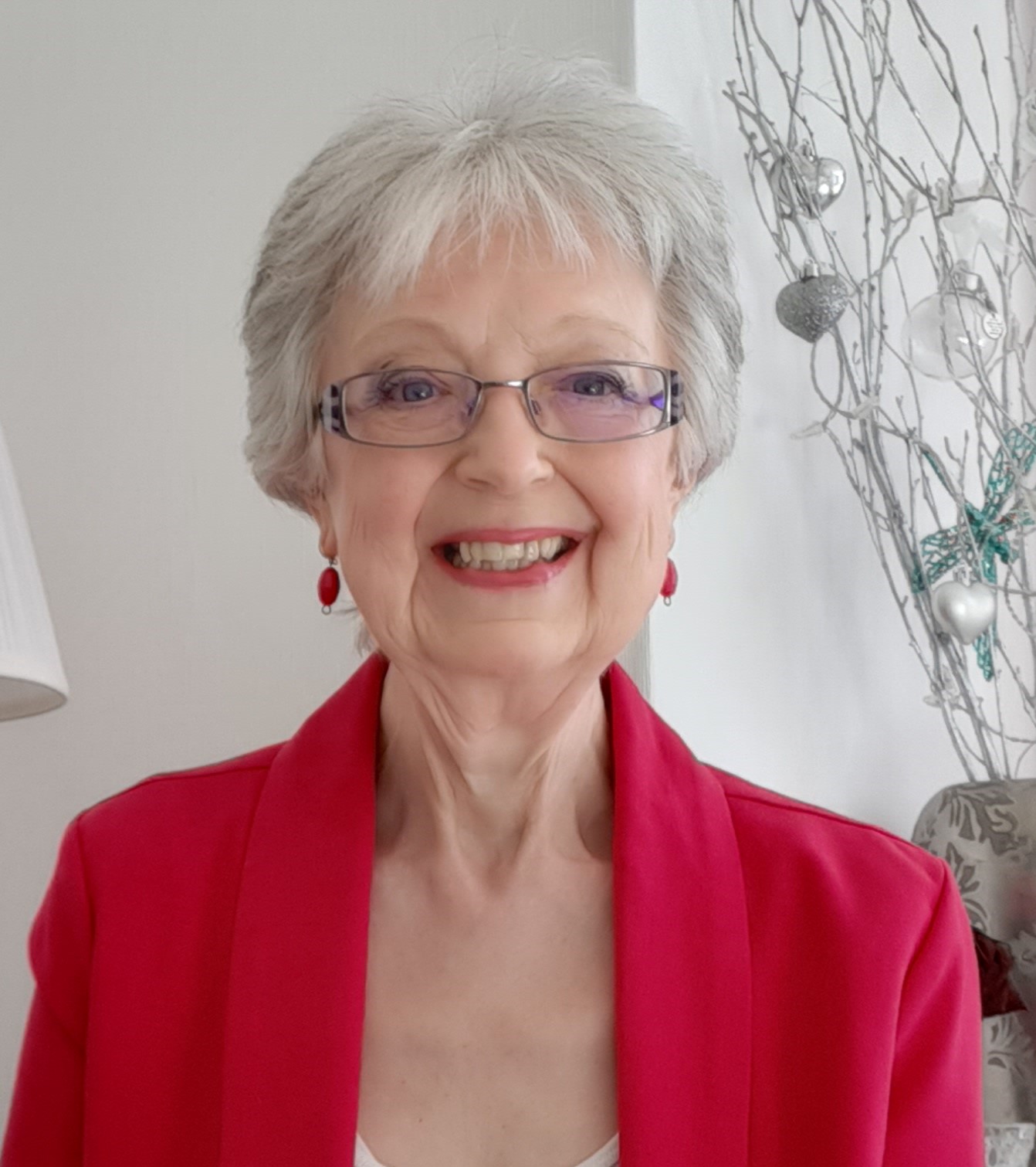 author yvonne j richards headshot with grey hair, smiling wearing bright pink jacket